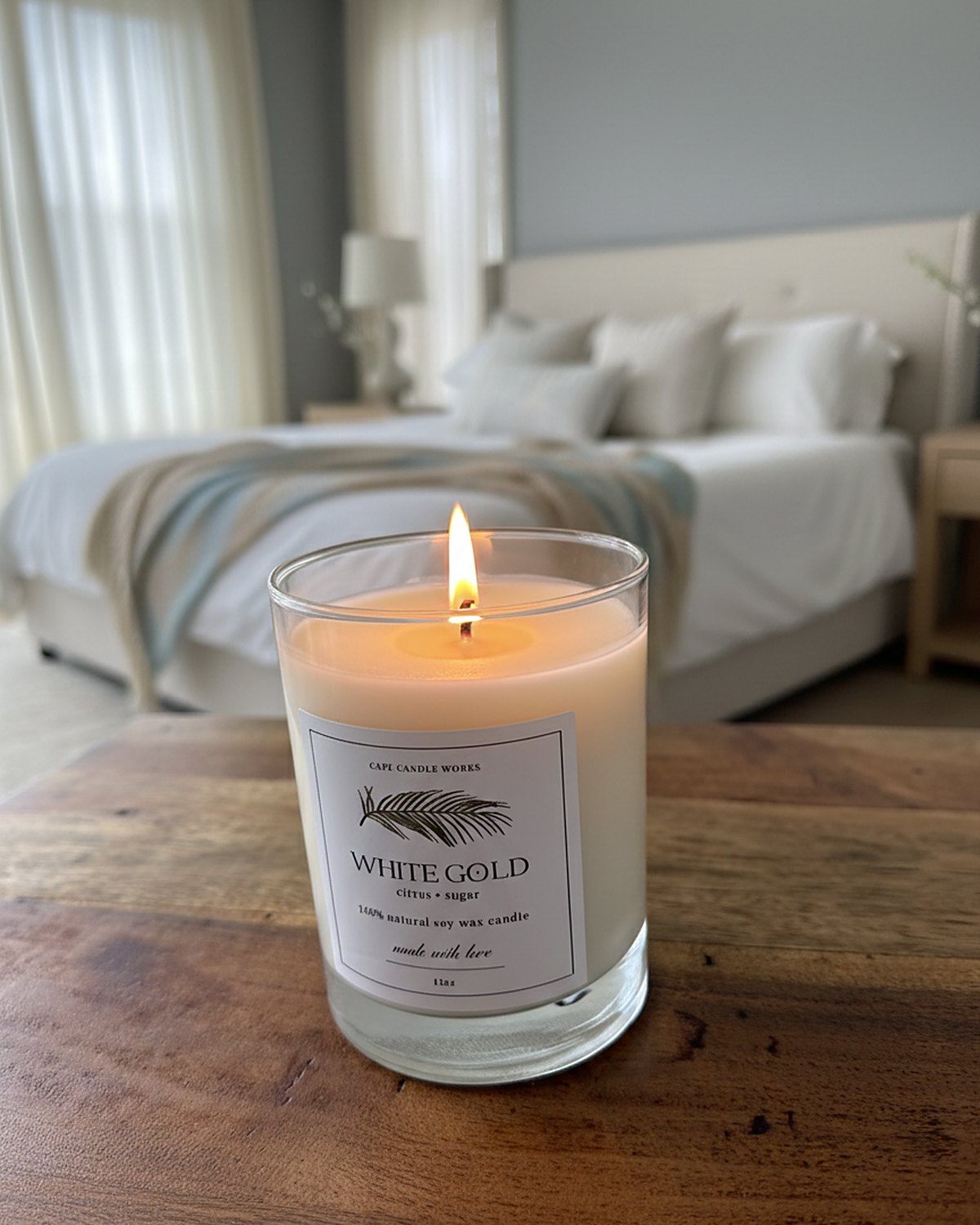 White Gold soy candle lit on a bedside table
